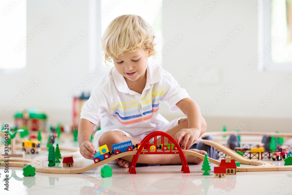 Kind spielt mit Spielzeugeisenbahn 